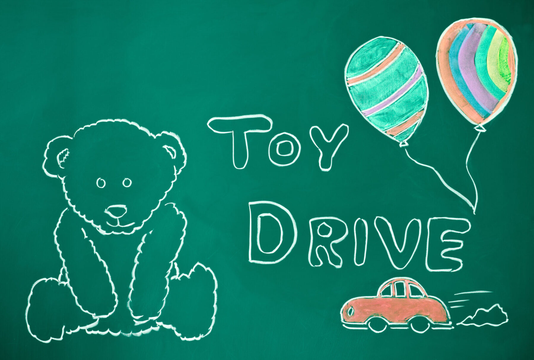 Toy drive concept on a blackboard. Cuddly teddybear waiting to meet his new owner.